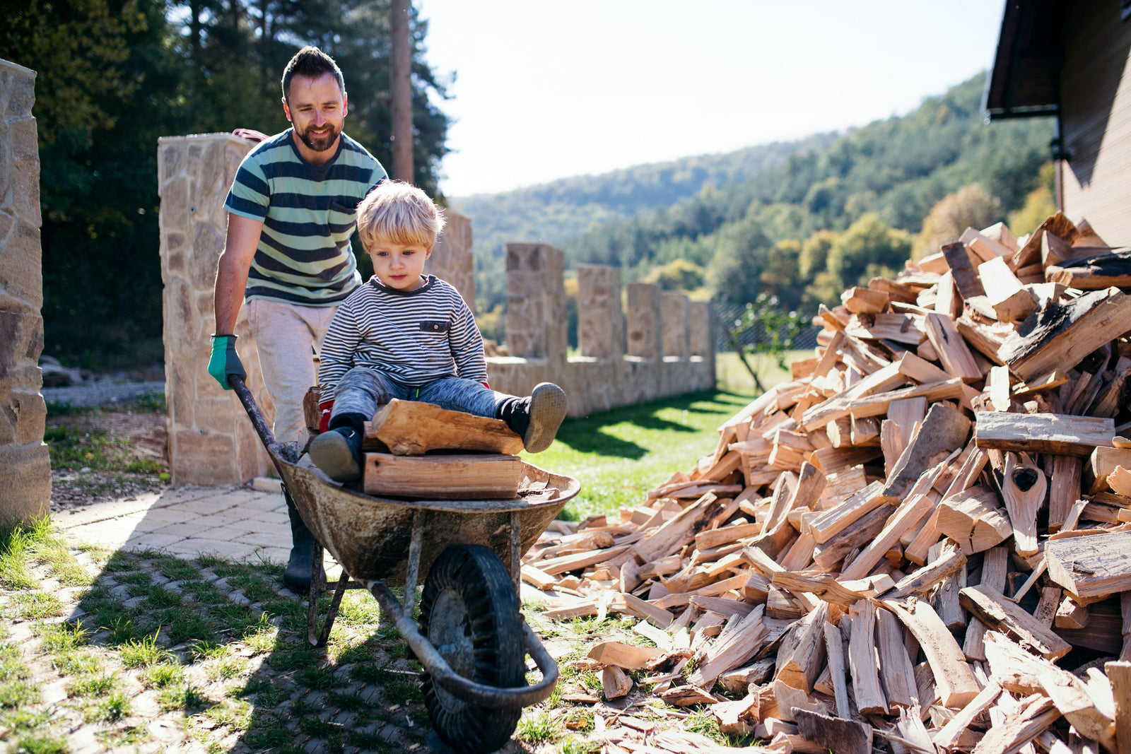 Vater und Kind transportieren Brennholz für den Kaminofen